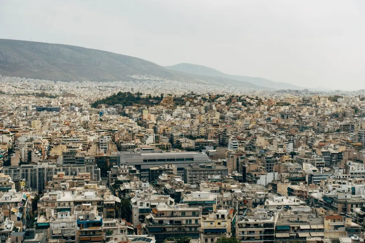 Πόλη με πυκνή δόμηση, λόφους στο βάθος, ασφάλεια σπιτιού για φυσικές καταστροφές
