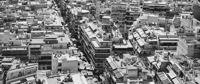 ΑΤΑΚ ακινήτου, πόλη από ψηλά με πολυκατοικίες, φαίνονται ταράτσες και τέντες