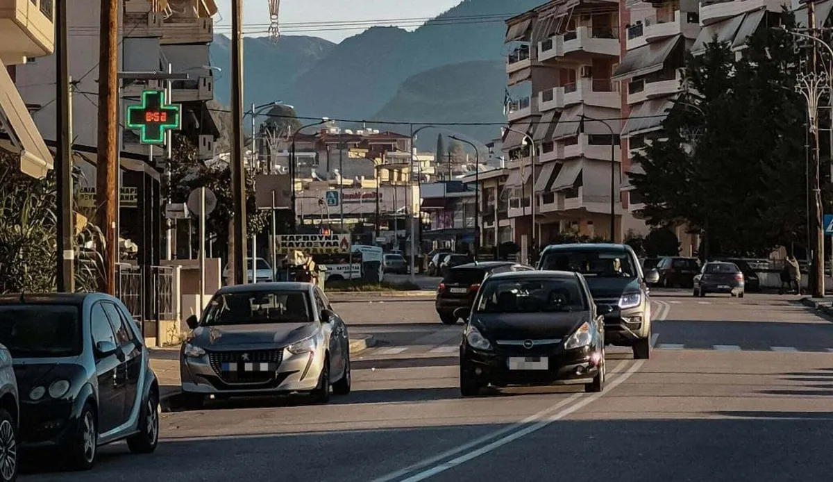 δρόμος πόλης μέρα, όρια ταχύτητας σε αστικό οδικό δίκτυο, αυτοκίνητα εν κινήσει και παρκαρισμένα, δεξιά κι αριστερά πολυκατοικίες