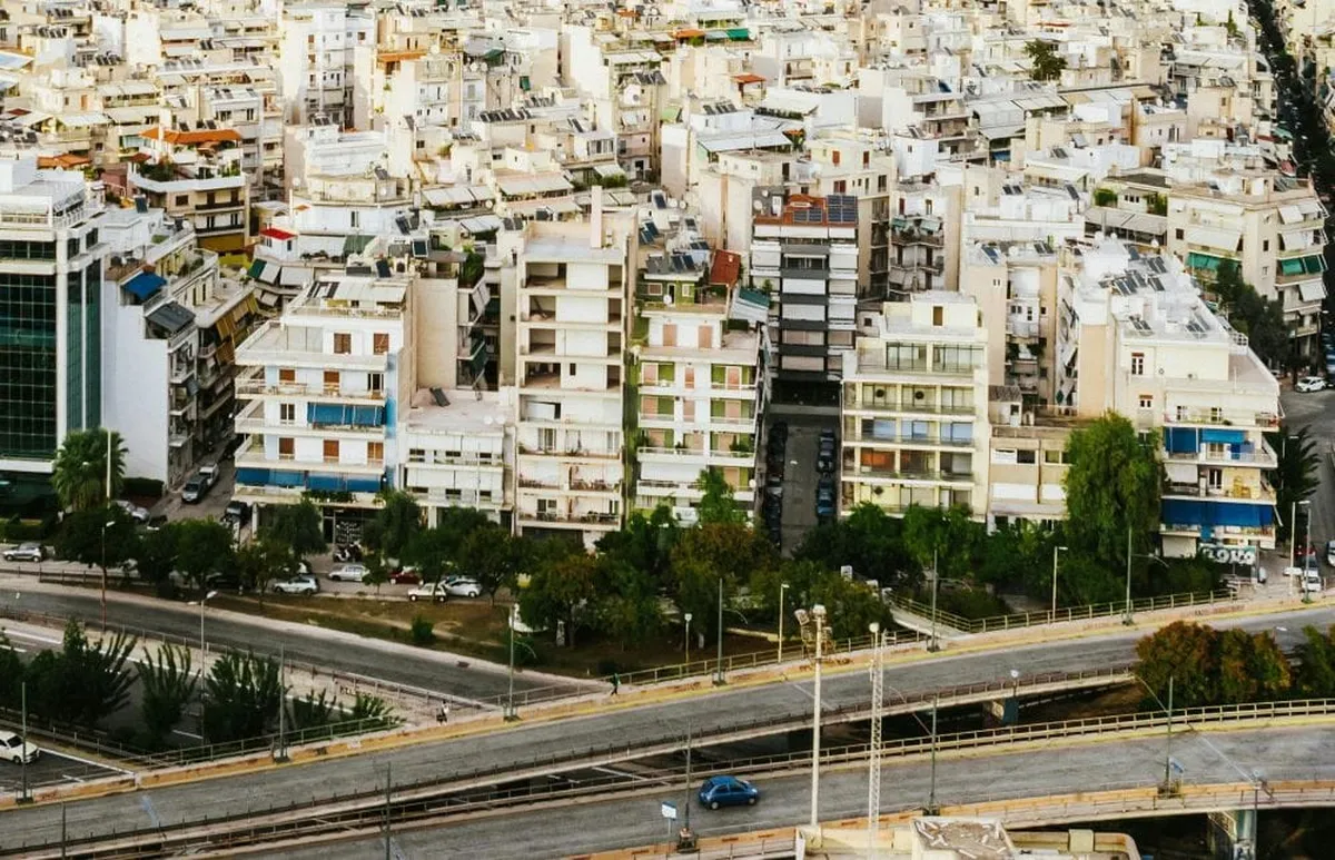 δρόμος με αυτοκίνητο από ψηλά, στο φόντο πολυκατοικίες, για το θέμα διασταυρωτικοί έλεγχοι οχημάτων