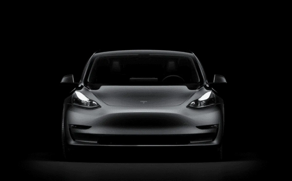 Μαύρο αυτοκίνητο Tesla από μπροστά σε μαύρο φόντο
